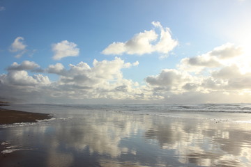 Reflecting Clouds on the Surf on Pacific Ocean at Manzanita Beach in Oregon