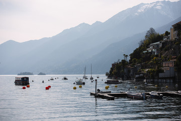 Swiss city shore, against the backdrop of the mountain, boats moored on the water