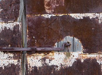 Old rusty door being held shut with new lock
