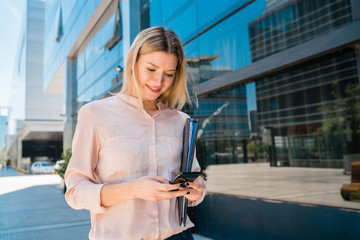 Business woman using her mobile phone outdoors.