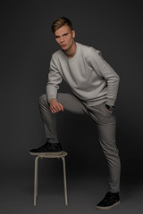 Sexy boy is posing on grey background in studio. Isolated