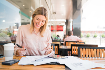 Young businesswoman working at coffee shop.