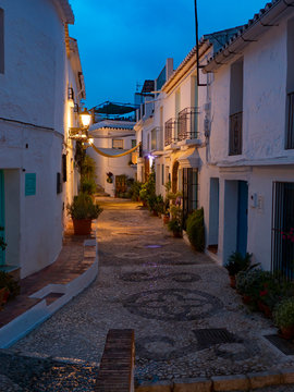 Calle espa&ntilde;ola de Andaluc&iacute;a de la costa del sol amaneciendo llena de macetas y fachadas de cla
