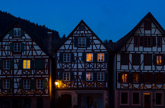 fachadas medievales de casas entramadas con ventanas iluminadas por la noche