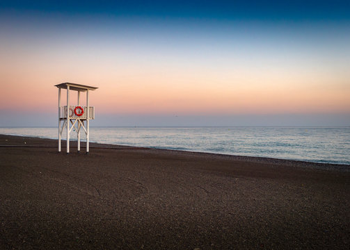Amanecer de playa desierta con puesto de guardavidas