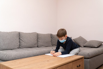 Coronavirus Epidemic. Isolated child Quarantined at Home in mask. Distance education and learning. Self isolation, home quarantine. World Crisis COVID-19. Distance learning at home.