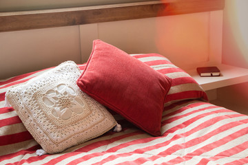 Bed detail with red bed covers and red and white cushions
