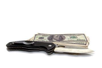 a folding knife with sharp blade next to a bundle of hundred-dollar bills.