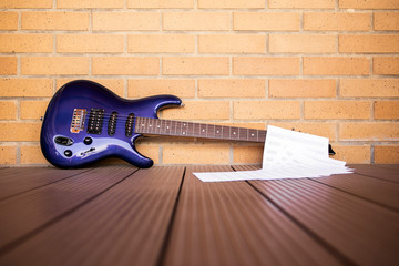 electric blue guitar with pentagram and brick wall