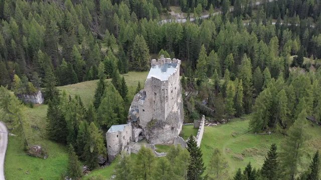 Aerial view of the castle Andraz in Italy. On a sunny day in Summer. Pan to the right around the castle. Dolomites scenery