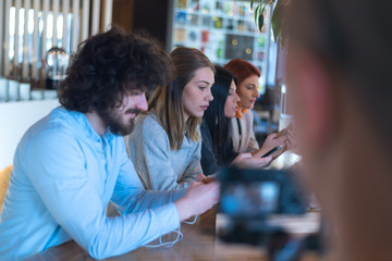Attractive guy and girl having a great time together at a coffee shop while using their mobile phones