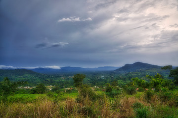 Fototapeta na wymiar Clouds gather above the hills and rain forest of sub-saharan West Africa in the bush of Ghana.
