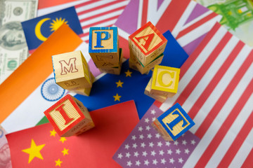 Fototapeta na wymiar Conceptual of global economic impact and uncertainties arising from outbreak, recession and conflicts. Wooden cubes and flags representing global. Focus on selective wooden cubes only.