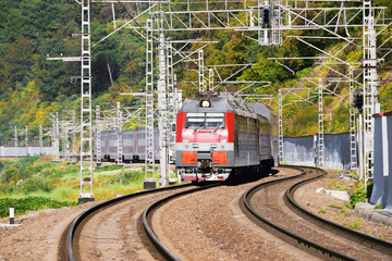 Obraz premium Passenger train moves by the mountain. Sochi.