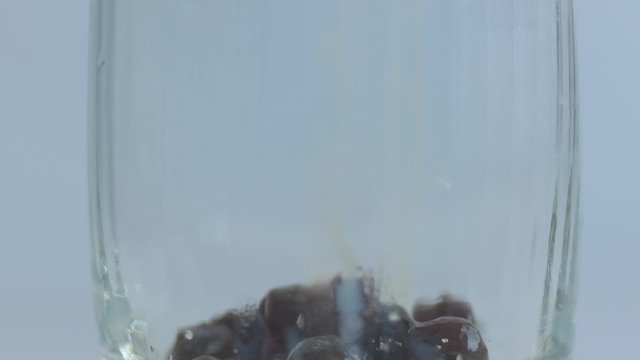 A closeup motion video of homemade tapioca ball been put in the glass and milk tea poured after that.