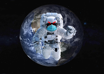 Obraz na płótnie Canvas Angry Astronaut in blue medical mask with painted red eyes and eyebrows near Earth planet of solar system at night. It is important to wear mask. Elements of the image were furnished by NASA
