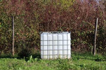 White new intermediate bulk container or IBC plastic tank with metal cage used for water storage...
