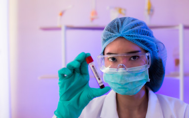 Fototapeta na wymiar selective focus woman wearing protect mask with test tubes blood test for virus. vaccine healthcare and medicine. 