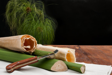 The making of papyrus paper: rolled up papyrus sheets, stems of a plant and the typical knife