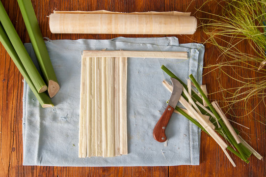 The making of papyrus paper: strips obtained from the stem of papyrus plant with a typical knife and a finished rolled up sheets