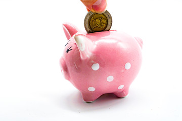 yuan coin dips into a pink piggy bank piggy bank

