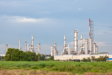 Oil refinery industrial factory with green field