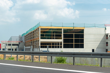 Fototapeta na wymiar Construction of a modern hall made of concrete slabs, visible concrete poles, construction site on the expressway.