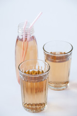 Two glasses and a bottle with Apple juice tubes on a white background