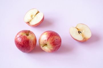 Cut and whole red Apple on a pink background
