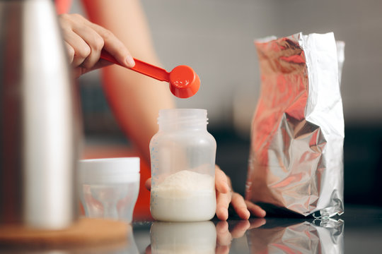 Mom Preparing Formula In Baby Bottle At Home