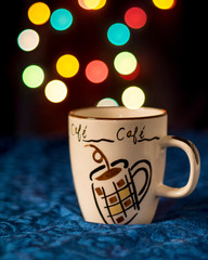 cup of coffee on a dark background with beautiful bokeh lights