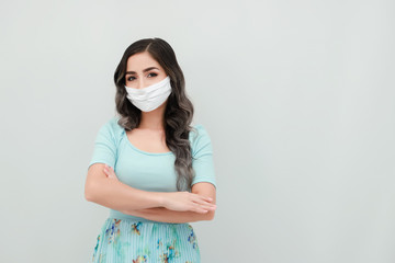 Young woman wearing medical mask crossed arms