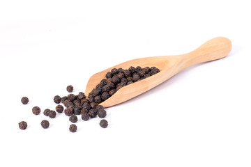 Closeup black pepper seeds or peppercorns ( dried seeds of piper nigrum) in wooden scoop isolated on white background.