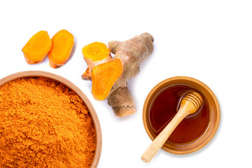 Dry turmeric power in wooden bowl and fresh curcuma root with pure gold honey isolated on white background. Top view. Flat lay.