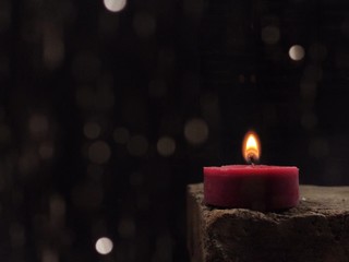concept for mourning with candle light on a black background and blurred boken, Soul and spirituality, Burning candle. Candle Flame
