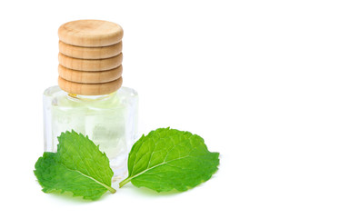 Closeup fresh green mint (spearmint) leaves with small glass bottle of peppermint essential oil extracted isolated isolated on white background. Natural herbal medical aromatic plant concept. © NIKCOA