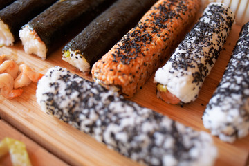 Ready-made sushi not cut are whole. We cook with our own hands, nori, shrimp, fish, a lot of sesame. Mat, board for nori seaweed.