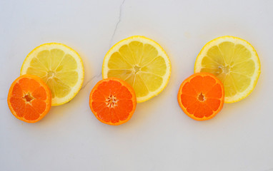 orange and lemon slices on a white marble background