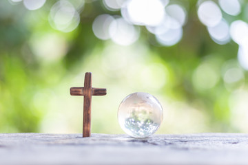 crucifix with glass world globe on nature bokeh background