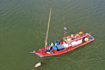 Traditional fishing boat loaded for a trip. Sailing under flag of Thailand 