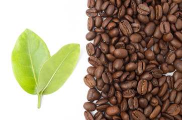 Raw coffee beans with leaf on white background.