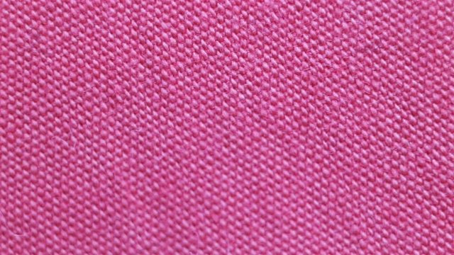 Dense thin pink microfiber non-natural fabric. Real time, camera movement, dense weave, texture, background, extreme close-up