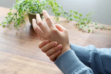 指をマッサージする女性