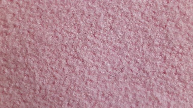Fluffy thick fleece pink non-natural fabric made of microfiber fiber. Real time, camera movement, loose texture, background, extreme close-up