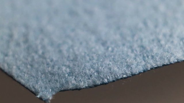 Fluffy very dense thin blue unnatural material made of microfiber fiber. Real time, camera movement, loose woven texture, background, extreme close-up, small depth of field