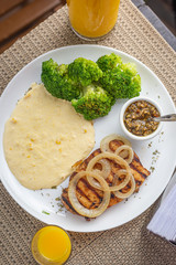 Typically Brazilian food with broccoli, corn cream and chicken steak