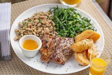 Typically Brazilian food with bottle butter, beans, steak, potatoes and cabbage