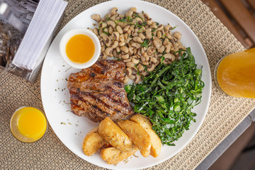 Typically Brazilian food with bottle butter, beans, steak, potatoes and cabbage