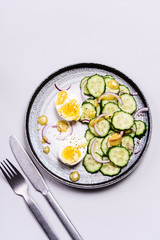 Easy vegetarian salad with cucumber, onion and eggs with vinaigrette sauce. Healthy nutrition. Selective focus