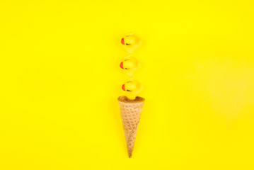 Rubber toy yellow cute rubber ducks In the ice cream cone on a yellow background.